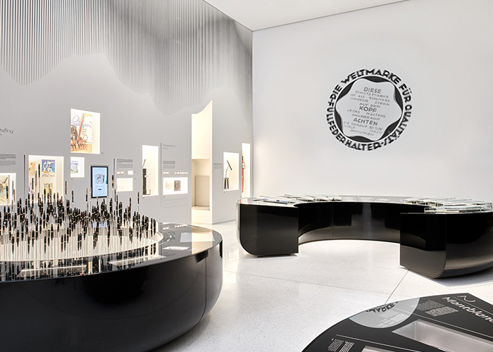 Montblanc Haus, Hamburg. Ausstellungsdisplays aus Corian<sup>®</sup> Deep Nocturne mit hochglanzpolierter Oberfläche und integriertem Multimedia-Bildschirm. Stifte sind wie Bäume in einen hinterleuchteten Sockel aus Corian<sup>®</sup> Glacier Ice gepflanzt. Wandnische in einer Corian<sup>®</sup> Glacier Ice Wand. Design von Projectiles; Herstellung durch Crea Diffusion; Bilder von Daniel Schafer, alle Rechte vorbehalten.